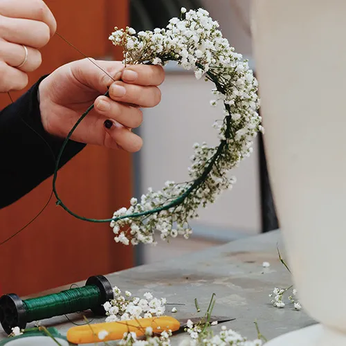 una florista acabando una corona de paniculata para el pelo