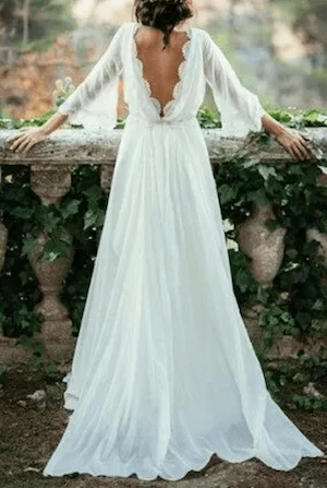 una novia apoyada con un vestido de novia chifon