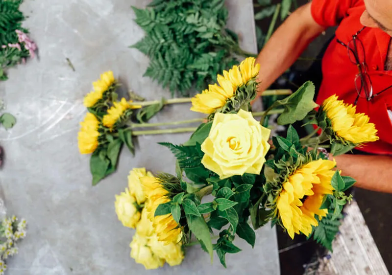 preparacion de un ramo de flores de girasoles y rosas amarillas
