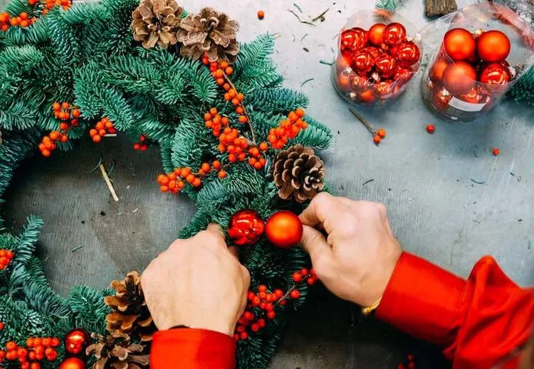 bayas de ilex rojo con piñas y una corona de pino