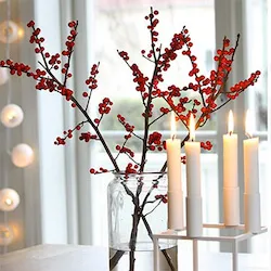 tallos de ilex rojo en con velas blancas