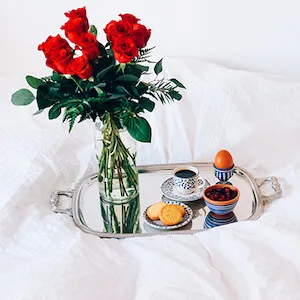 un ramo de rosas en la bandeja de desayuno en la cama