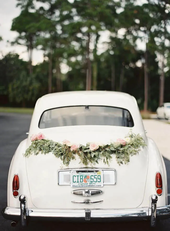 guirnaldas de eucalipto populis y rosas decorados encima de un coche vintage