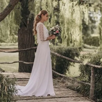 una novia con un ramo de novia con un estilo campestre con rosas blancas y rosas