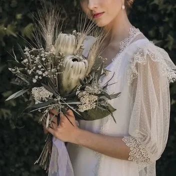 novia con un ramo de novia con proteas blancas
