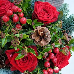 detalle de un ramo de navidad con rosas rojas y hipericum