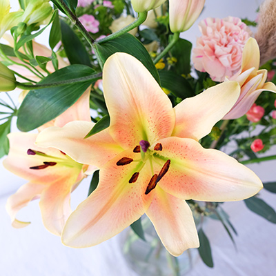 ramo de flores en colores salmon con lilium y claveles