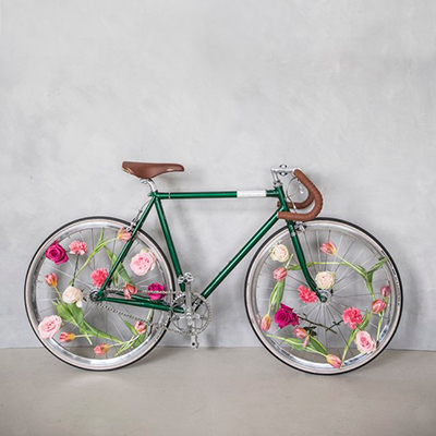 bicicleta aparcada con ruedas decoradas de tulipanes y rosas