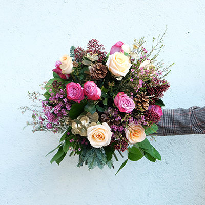 ramo de flores con rosas blancas y moradas y piñas