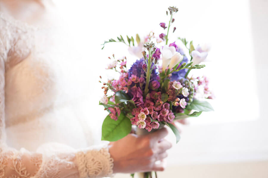 ramo de novia en tonos morados con alhelies y flor de cera