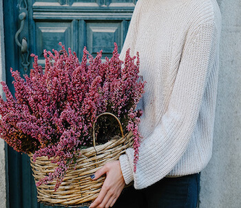 chica con una cesta de miembre con brezo
