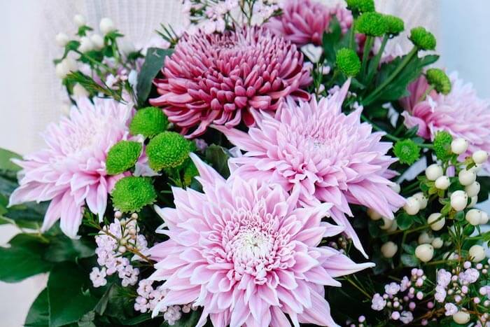 detalle de un ramo de crisantemos de colores vairados y bayas de hipericum