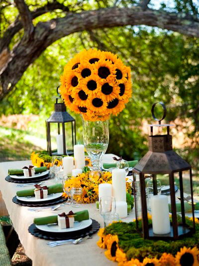 un pompon de girasoles en redondo sobre un jarron de cristal