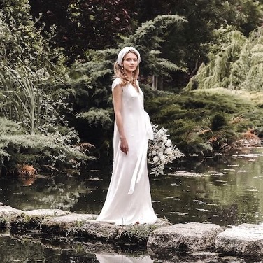 novia posando con un ramo de novia campestre en tonos blanco