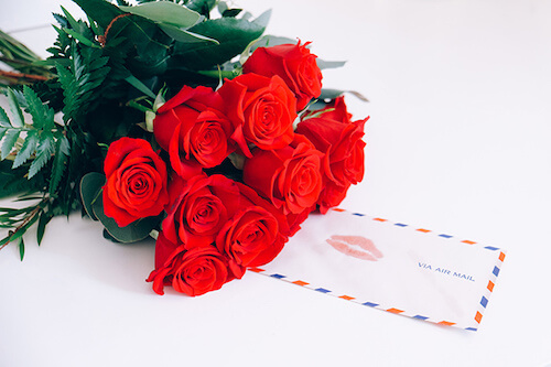 ramo de rosas rojas con una carta