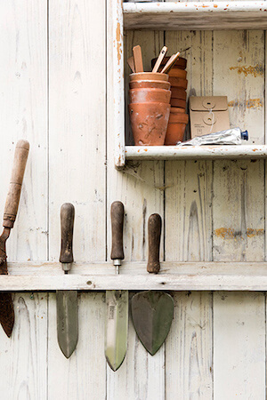 macetas de barro en un armario con herramientos de poder