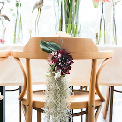 silla marron con tislandia y una dahlia morada