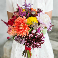 ramo de novia con de otoño campestre con dahlias naranjas y moradas