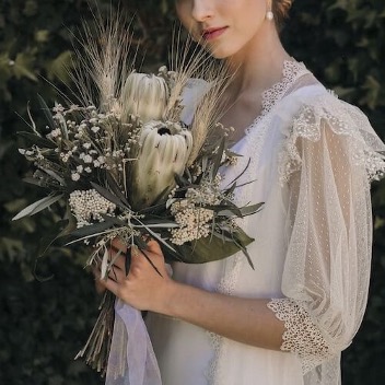 novia con un ramo de novia con proteas blancas